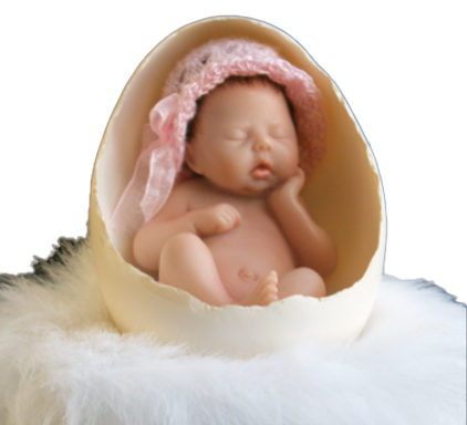 Cherished, a miniature newborn in a pink crochet bonnet sleeping inside an egg shell on white fur